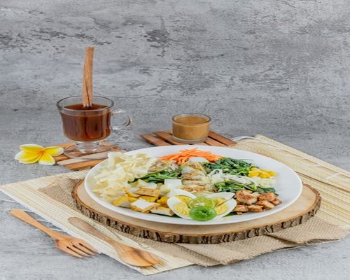Fresh Indonesian vegetables, tofu, and tempeh on a traditional wooden table