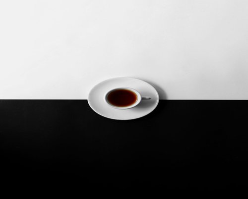 A simple black coffee and warm plain tea without added sugar on a table